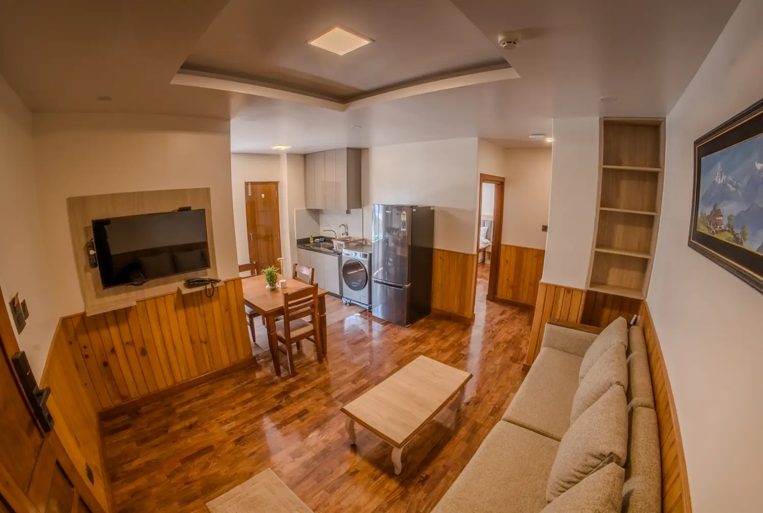 Living room with wood panelling and kitchen